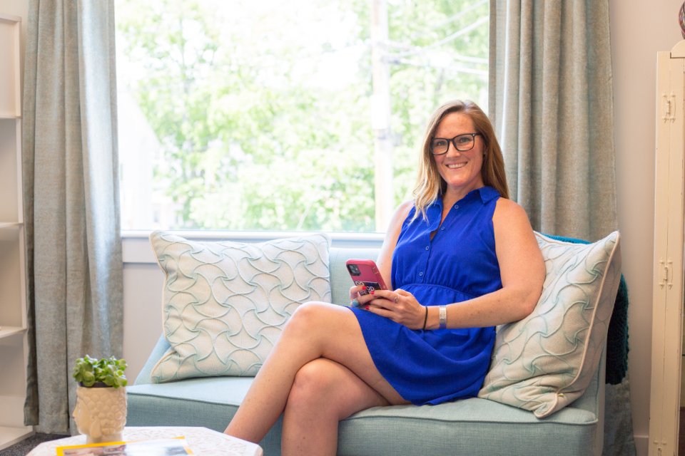 Woman on a sofa holding her phone
